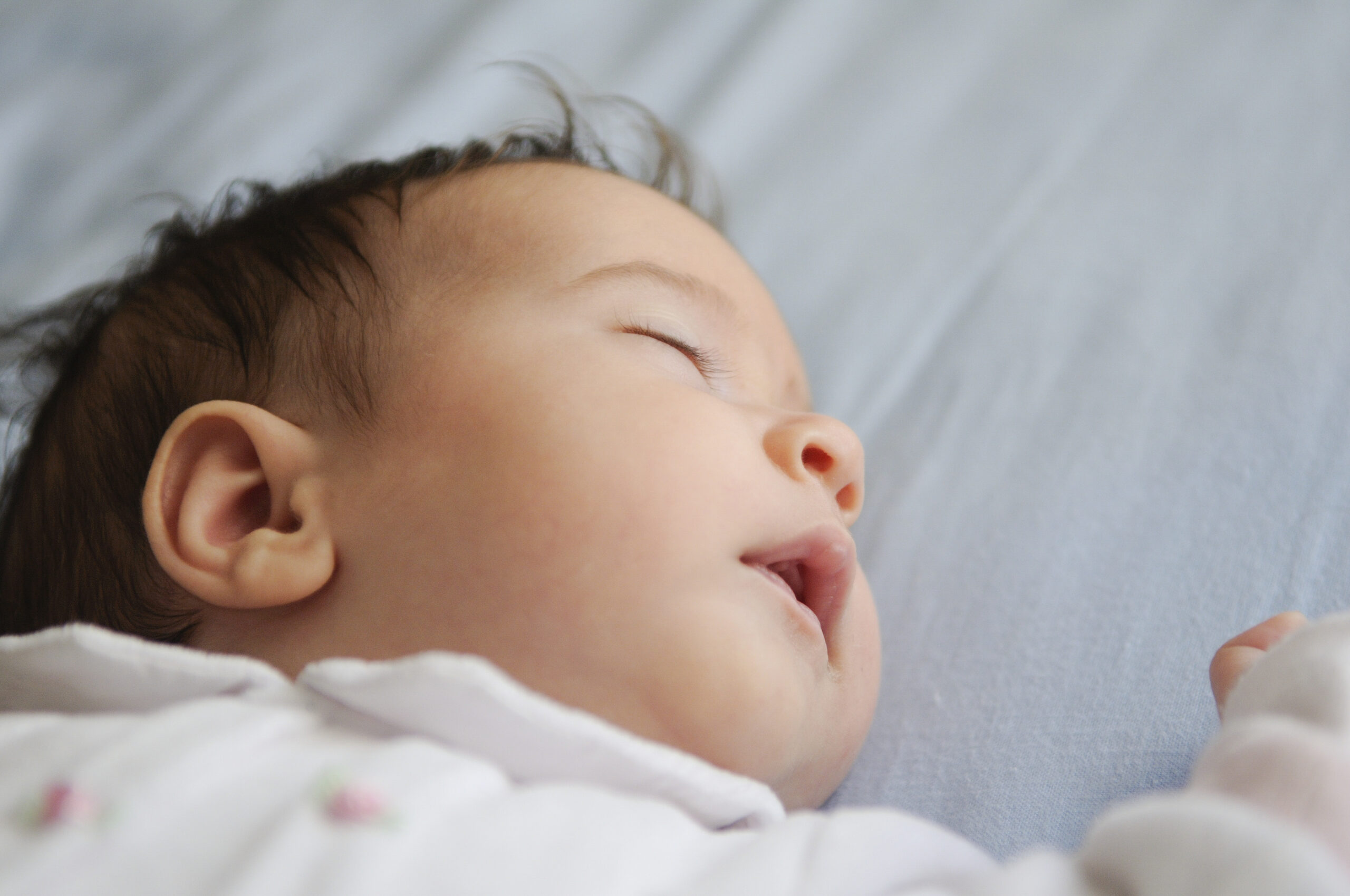 newborn baby girl sleeping on blue sheets FLRHUCK scaled